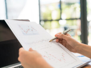 Business woman hand with Financial charts and laptop on the tabl